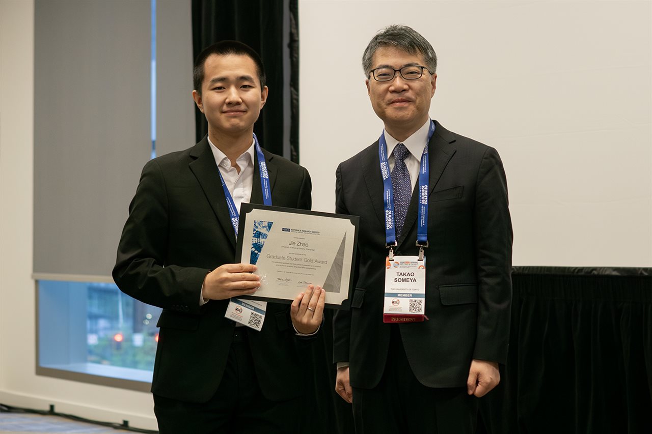 Jie Zhao, with his award in his hands, stands with the Materials Research Society President.